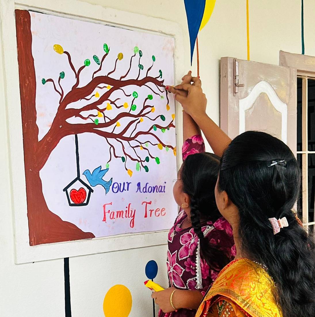 A parent adding to the family tree painting